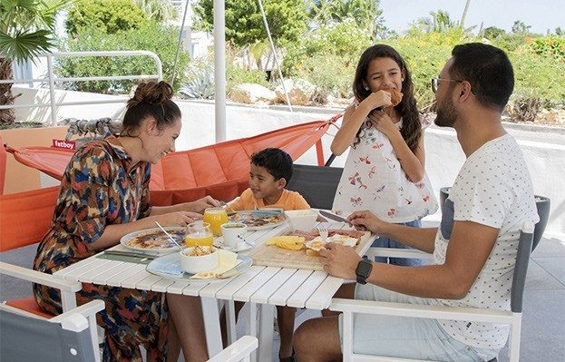 Een familie geniet van hun ontbijt in het Chogogo resort.